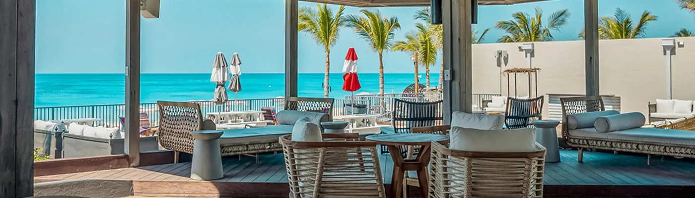 Beach Club 360’s oceanfront lounge seating and umbrellas at Resorts World Bimini